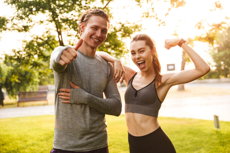 Deux stagiaires en formation BPJEPS Activités de la Forme s'entraînent en plein air, souriants et motivés, incarnant l’esprit d’équipe et la passion du coaching sportif.