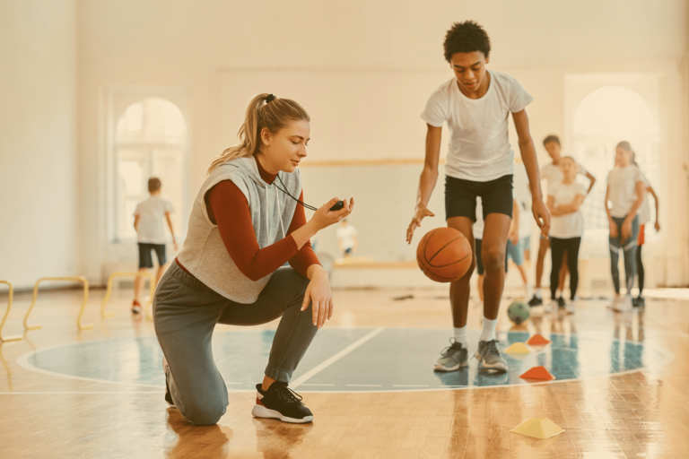Exercice d’entraînement encadré en salle lors de la formation BPJEPS Activités de la Forme : un formateur chronomètre un élève en pleine course avec ballon, illustrant la pratique professionnelle et l’accompagnement pédagogique.